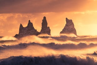Gewaltige Felsnadeln vor der Küste in der Nähe des schwarzen Sandstrandes von Reynisfjara.