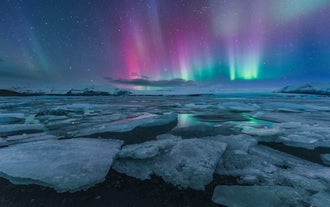 Les aurores boréales dansent de diverses couleurs sur le lagon glaciaire de Jökulsárlón.