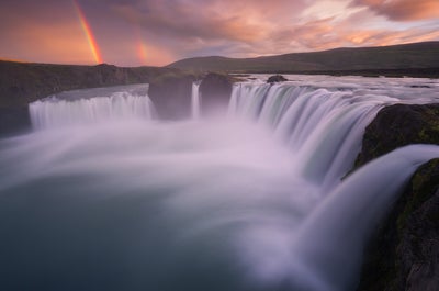 The mighty and beautiful waterfall Goðafoss thunders into the Skjálfandafljót river accompanied by a gorgeous rainbow.