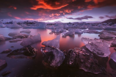 ภูเขาน้ำแข็งที่เปล่งประกายและสะท้อนสีที่อบอุ่นในตอนเย็นที่ทะเลสาบธารน้ำแข็งโจกุลซาลอนในทางตะวันออกเฉียงใต้ของประเทศไอซ์แลนด์.