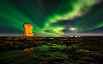 Ein Leuchtturm ist der perfekte Vordergrund für ein beeindruckendes Foto der Aurora Borealis.