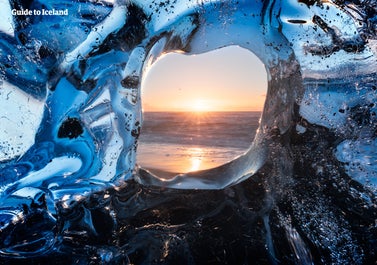 Der Blick durch einen Eisbrocken am Diamantstrand im Süden Islands.