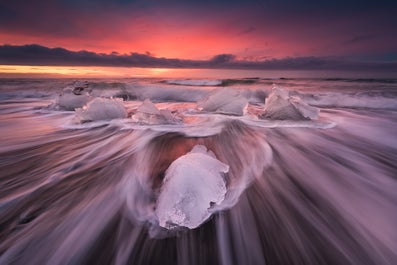 Eisberge funkeln wie Diamanten auf einem schwarzen Sandstrand in der Nähe der Gletscherlagune Jökulsarlon.