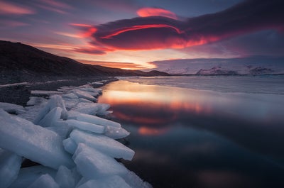 Black sands, white snow and golden sunset at Reynisfjara black sand beach.