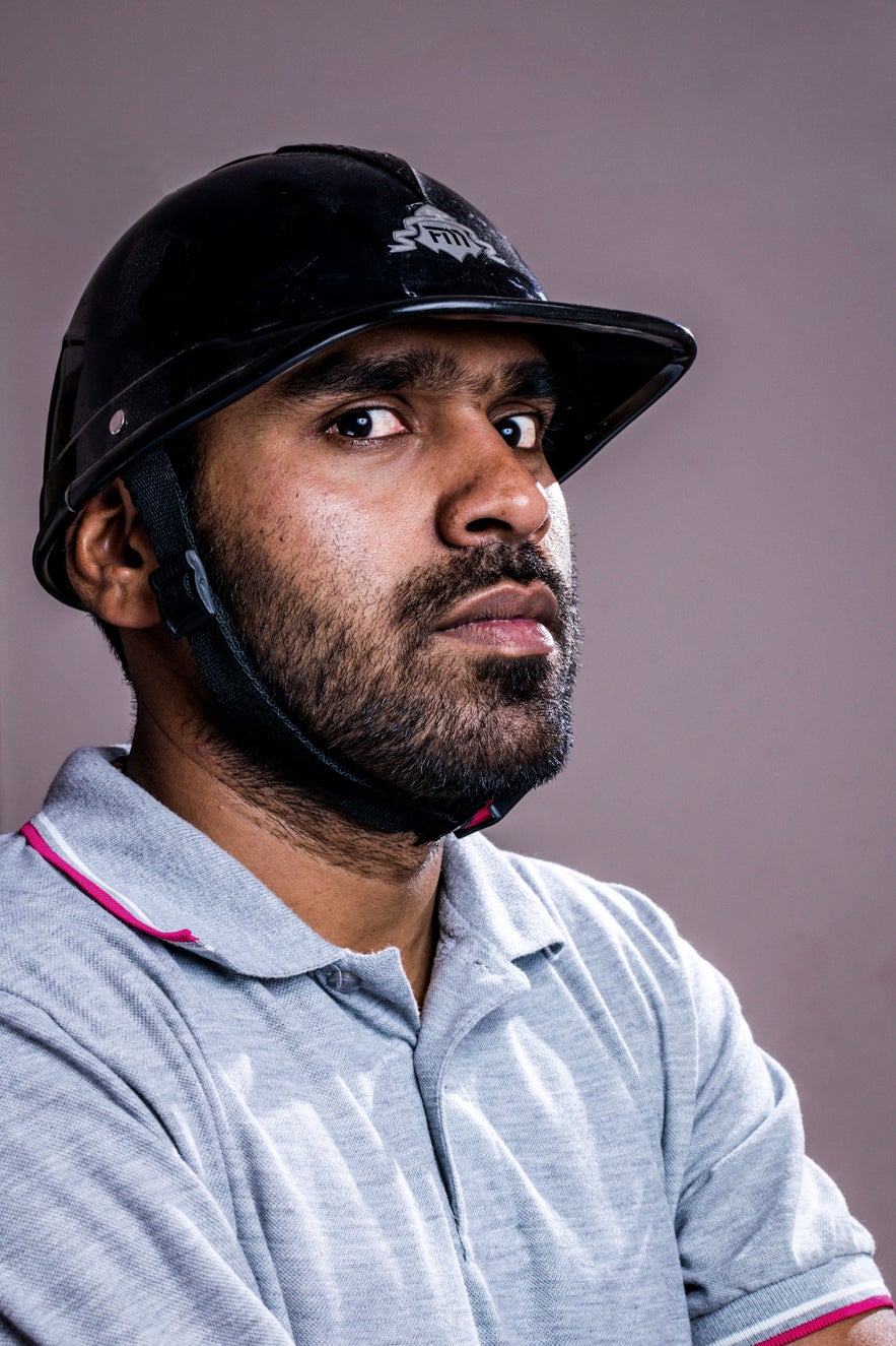 A man in a polo helmet and polo shirt looks at the camera with a sideways glance A man in a polo helmet and polo shirt looks at the camera with a sideways glance
