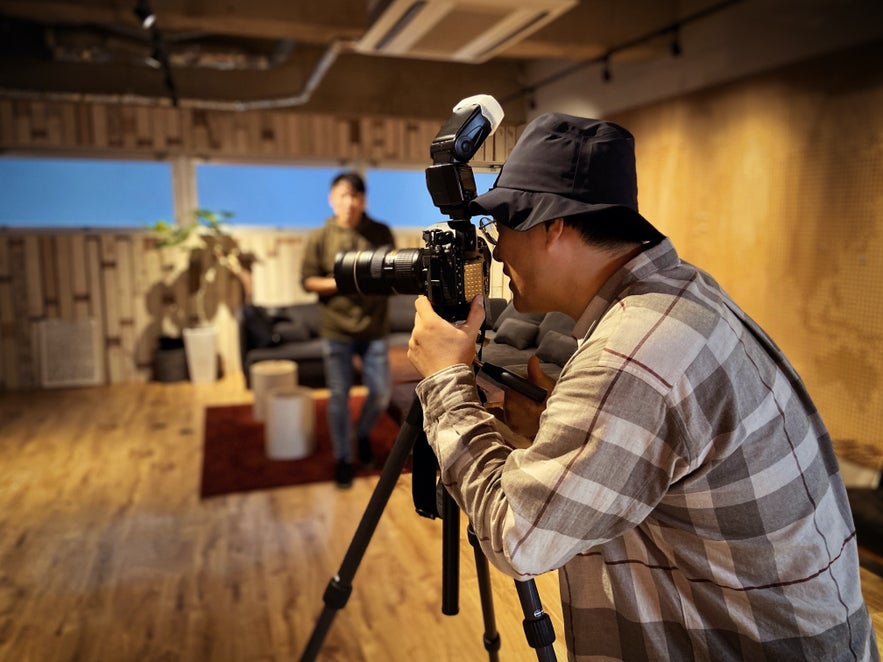 A man shoots with his on-tripod camera, bouncing the flash away from the subject A man shoots with his on-tripod camera, bouncing the flash away from the subject