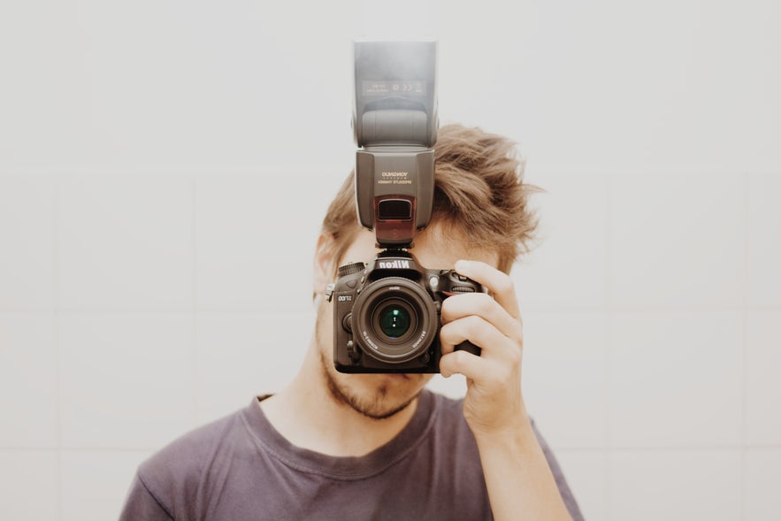 Guy holding a camera in front of his face Guy holding a camera in front of his face
