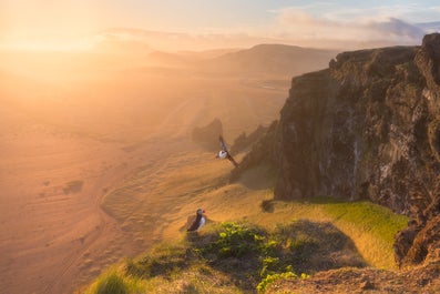 Puffins fly from the cliffs off Icelands' South Coast.