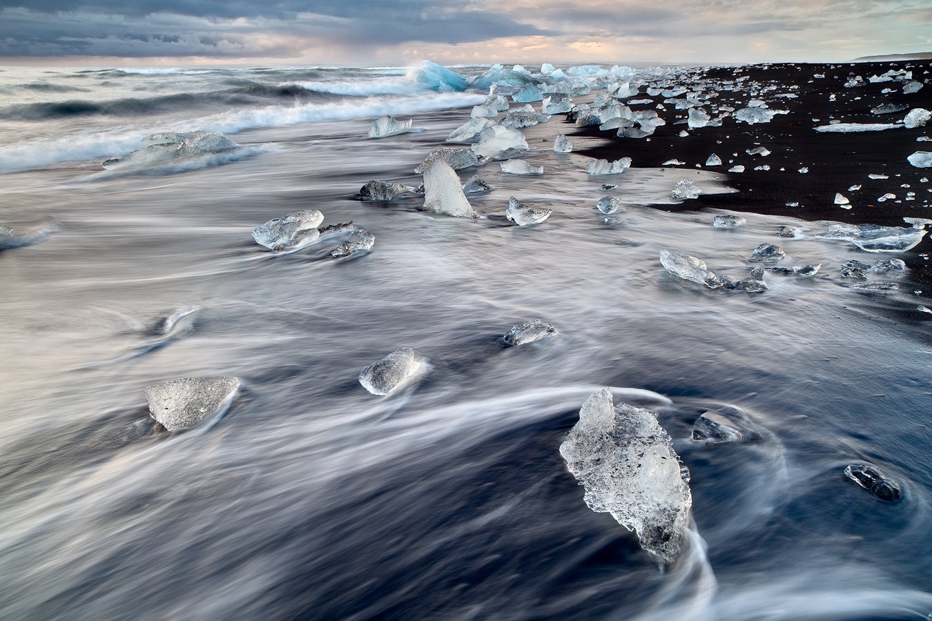 Glistening icebergs washed ashore on Diamond Beach, creating a stunning contrast against the black sand and sparkling like diamonds in the sunlight.