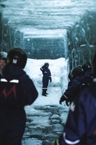 People stand inside an ice tunnel showcasing the inner workings of the Langjokull glacier.