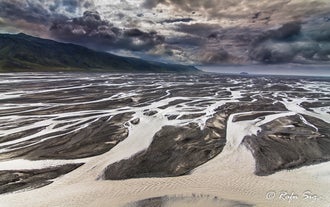 Witness the mesmerizing dance of nature's artwork from above - the braided river weaving its way through Iceland's picturesque landscapes.
