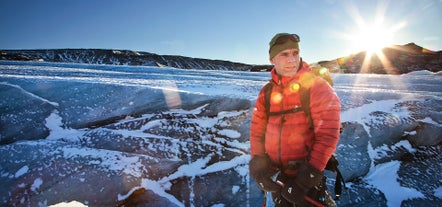 A person on a Solheimajokull glacier hike with the sun shining behind.