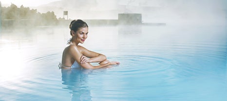 A woman smiles as she relaxes at the Blue Lagoon geothermal spa.