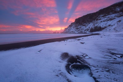 Der Blick von Vik i Myrdal in Südisland über den Strand Reynisfjara und den Berg Reynisfjall im Winter ist spektakulär.