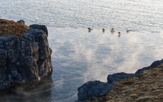 People relax in an infinity pool at Iceland's Sky Lagoon geothermal spa.