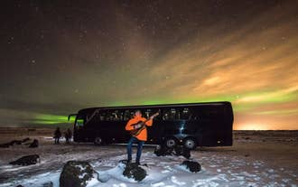 A traveler posing while surrounded by the magical northern lights.