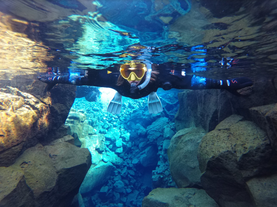 A woman explores the underwater wonders of Silfra during an unforgettable snorkeling adventure.