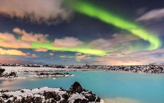 The northern lights shining above the Blue Lagoon during the Icelandic winter.
