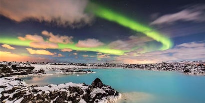 The northern lights shining above the Blue Lagoon during the Icelandic winter.