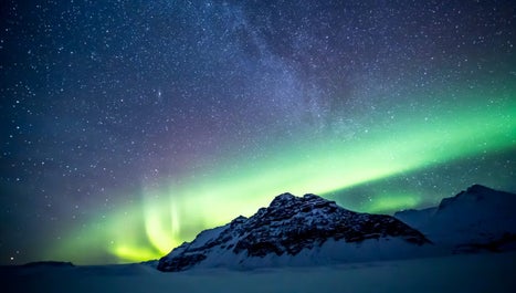 Dancing curtains of vibrant Northern Lights illuminate the night sky in a mesmerizing celestial display.