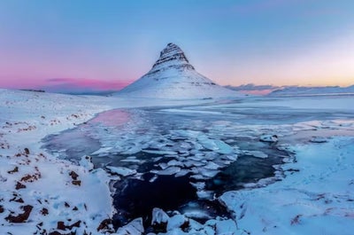 Majestic Kirkjufell mountain adorned in a blanket of winter's pristine beauty.