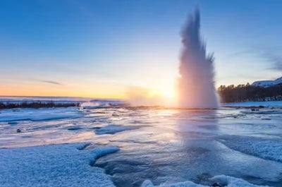 Strokkur geyser erupts in a stunning display of icy beauty during a winter morning.