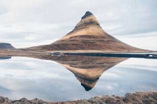 Kirkjufell mountain's beautiful formation reflects through the surrounding waters in Snafellsnes.