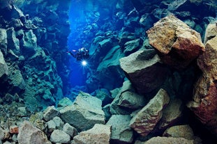 A diver explores the rocky walls of Silfra fissure in Iceland.