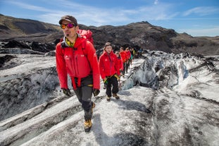 People walk in a line up the glacier during a guided tour at Solheimajokull.