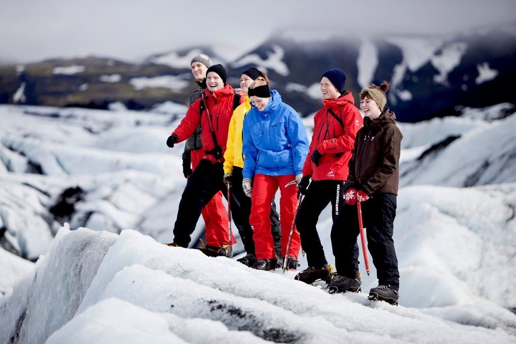 People stand in a line on the Solheimajokull glacier during an easy-level guided walk.