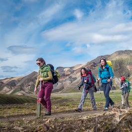 Hikers discover the incredible beauty of the Laugavegur trek on a sunny, blue-sky day.