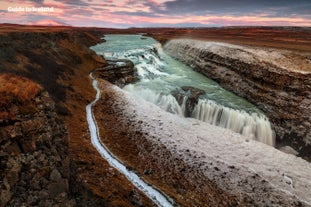 Ice and snow partially cover the Gullfoss waterfall in winter.